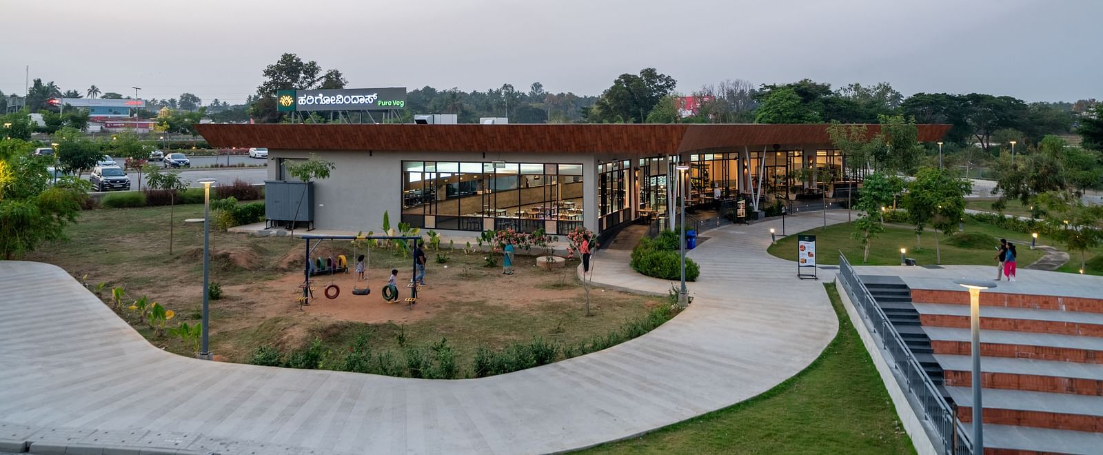 Distance view of Hari Govinda's restaurant, with the front covered by a footpath and the back shaded by trees
