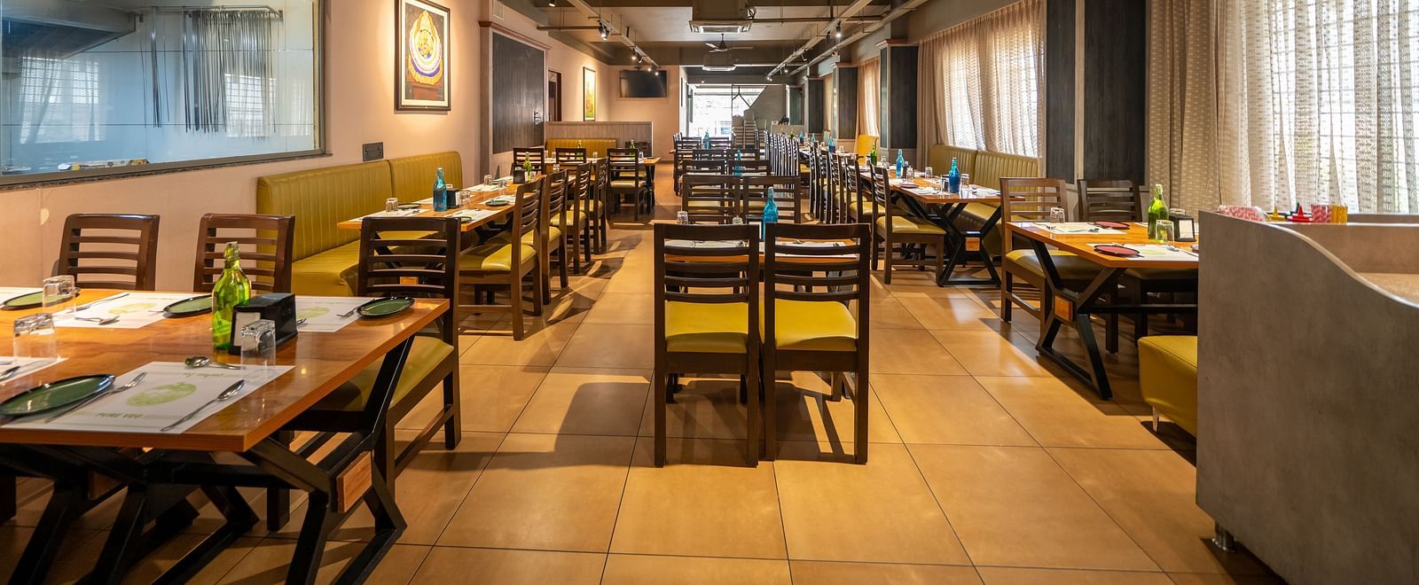 Image of a dining area with wooden tables and chairs at Hari Govindas, Siddappa Square.