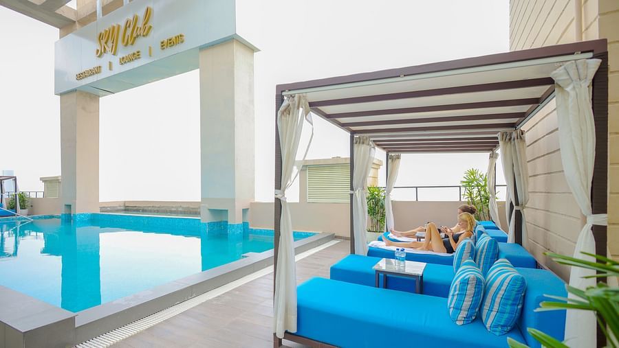 an image of a crystal clear swimming pool with sun decks at Rhythm Gurugram.