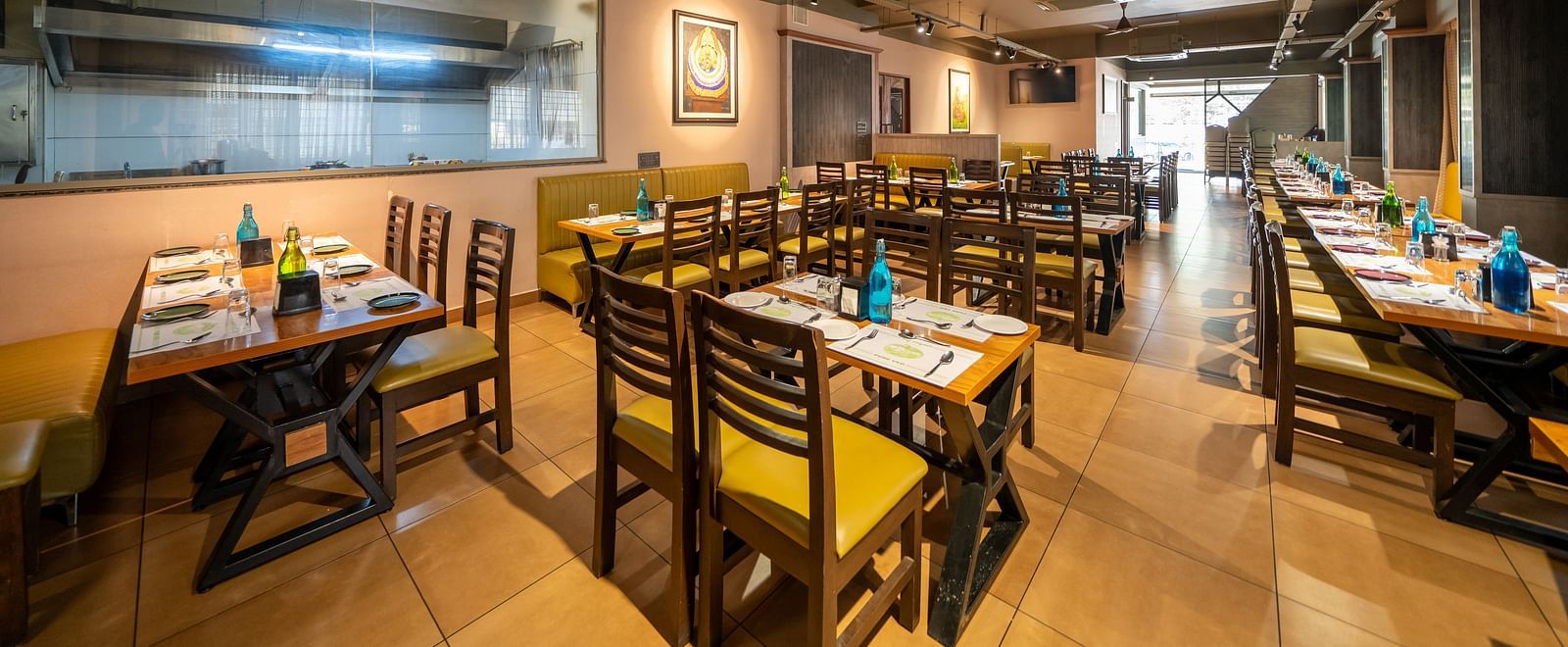 Image of a dining area with tables and chairs arranged around it at Hari Govindas, Siddappa Square.