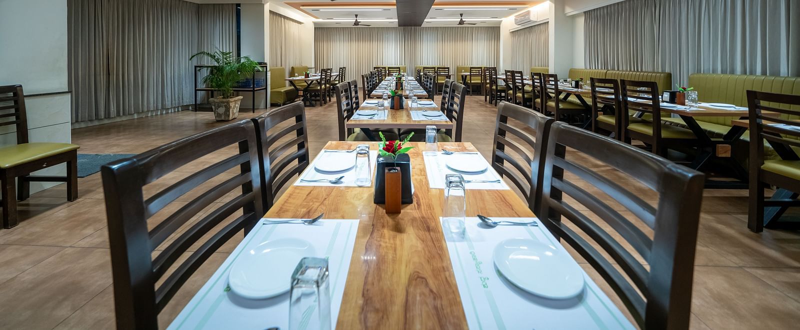 Dining area with close up view of the neatly set table and chairs kept on both sides of the table