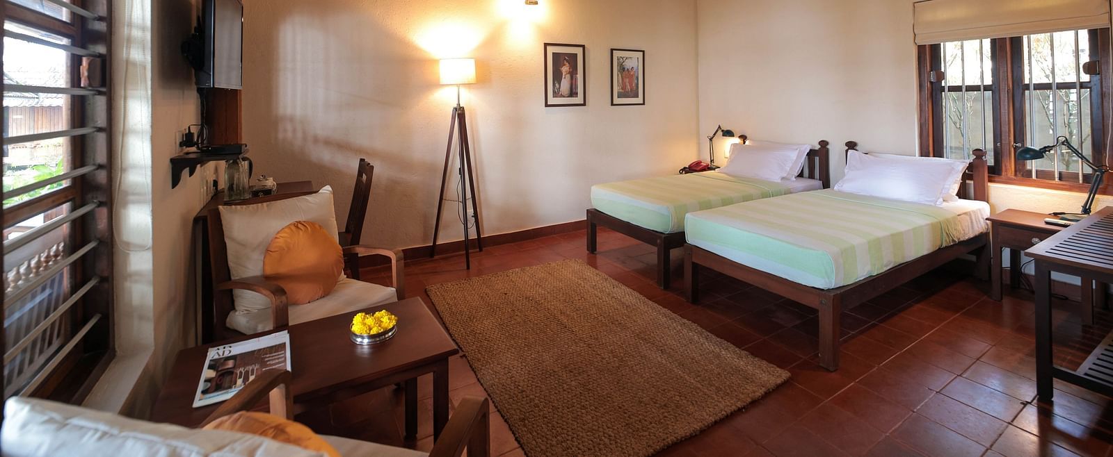 Twin beds placed in front of a desk in Lake Front Verandah Room at Samiira on Ashtamudi Lake. 