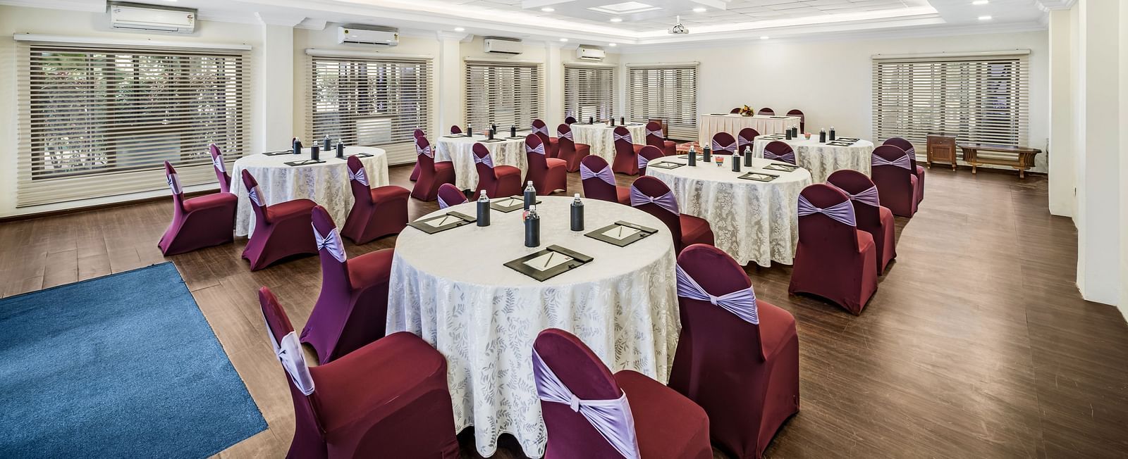An image of a banquet hall with seating arrangement and bright lighting - GReaT Trails River View Resort Thanjavur By GRT Hotels