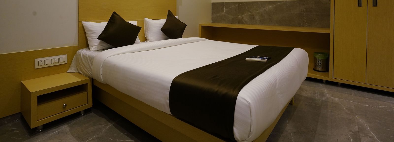 Hotel room with a double bed, bedside table, and warm lighting - Shyanu Lords Eco Inn Airoli