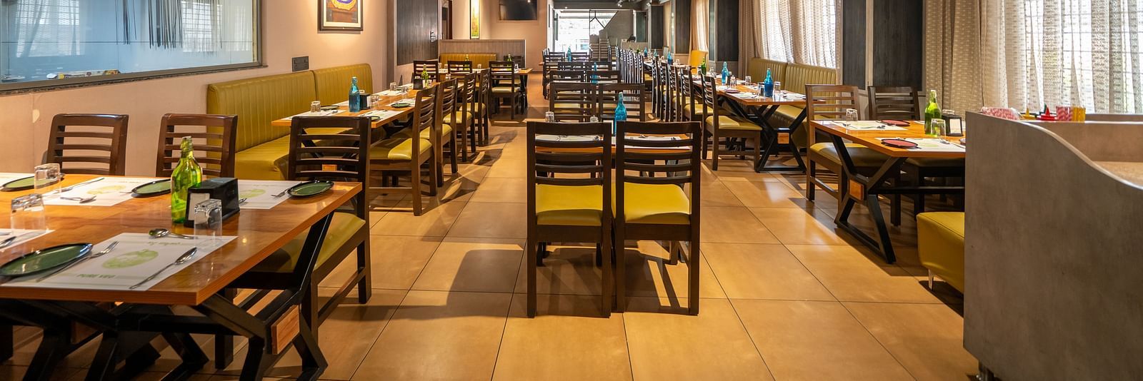 Image of a dining area with wooden tables and chairs at Hari Govindas, Siddappa Square.