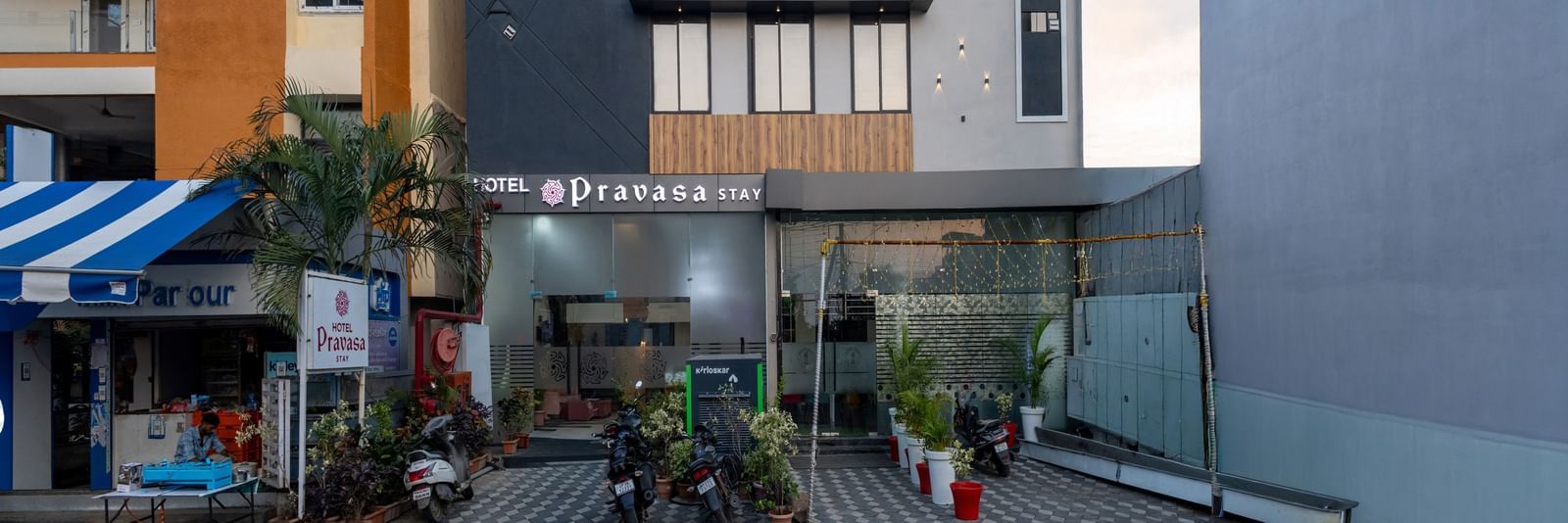 The facade of a modern multi-storey Pravasa Stay Dewas Naka, Indore under the blue sky.