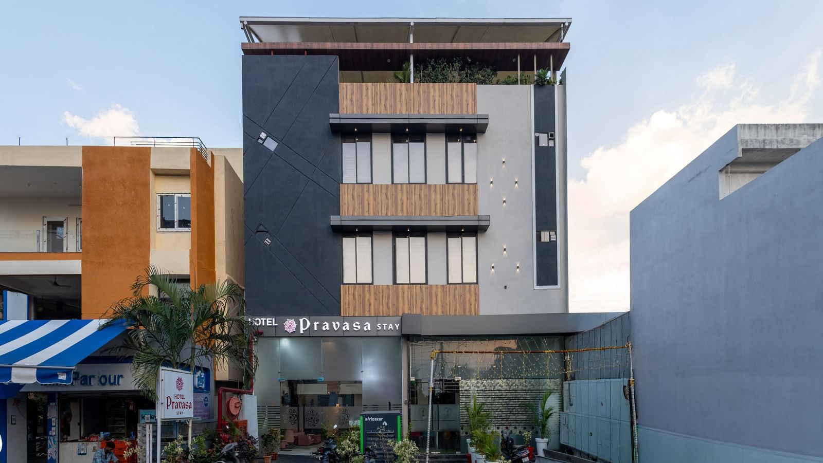 The facade of a modern multi-storey Pravasa Stay Dewas Naka, Indore under the blue sky.