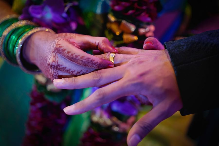 bride putting ring on groom's hand