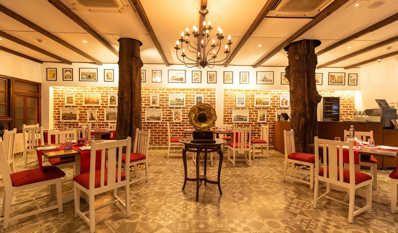 Interiors of Asian Table at Saraca Hotel, Lucknow with white and red theme for the tables and warm lighting with wooden pillars