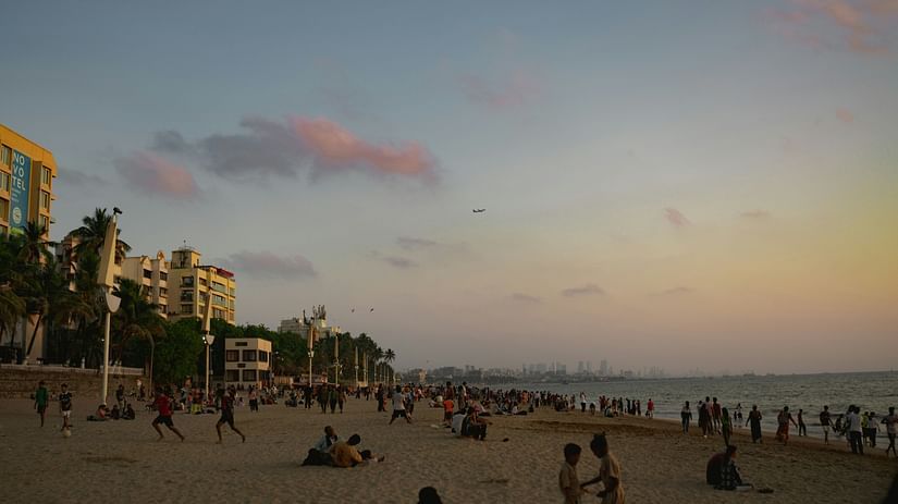 A view of people moving about on the sand of Juhu Beach.