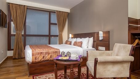 An image of a room with a queen size bed, TV and a chair and a table - Sumitel Vista TV Tower