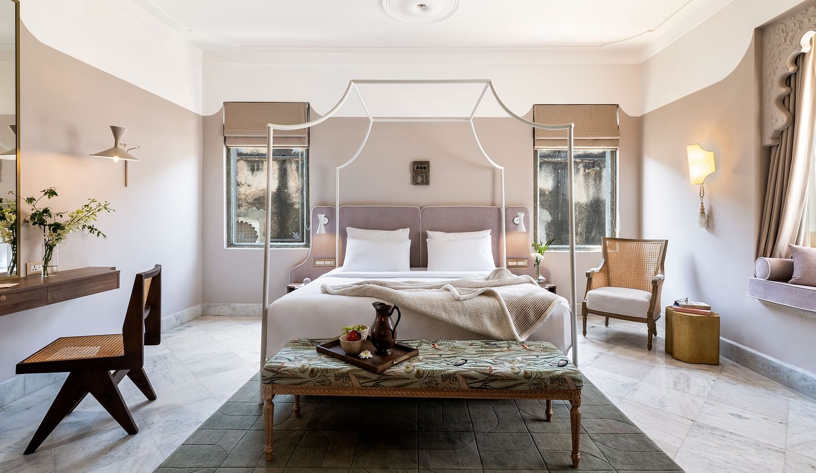a double bed with a small seating area at the base of the bed inside one of the rooms - Manuscript - Jhilwara Haveli, Udaipur