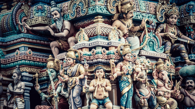 A facade image of a temple with faces of the gods