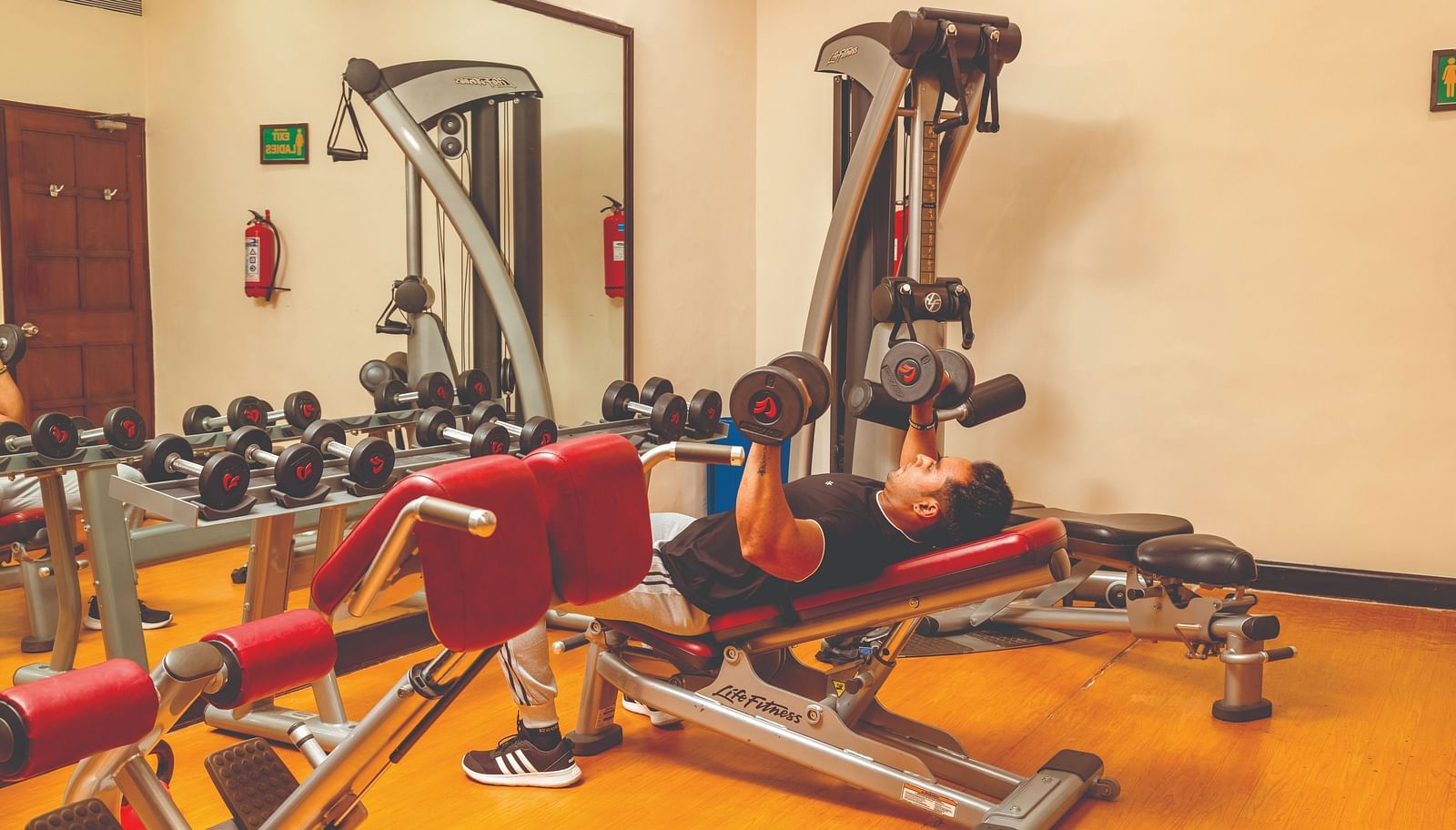 a person working out in the gymnasium with many equipment inside it - Caravela Beach Resort Goa