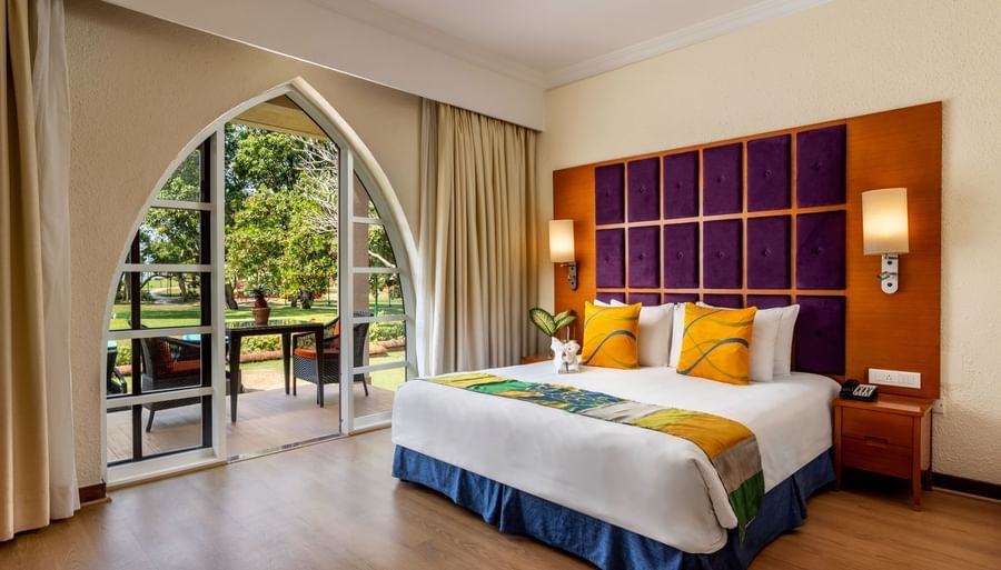 a double bed with cushioned headboard, lamps and side tables inside 2 Bedroom Garden Villa - Caravela Beach Resort Goa