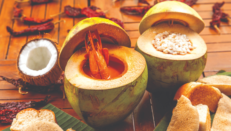 two coconuts cut open and with drinks inside it - Caravela Beach Resort Goa