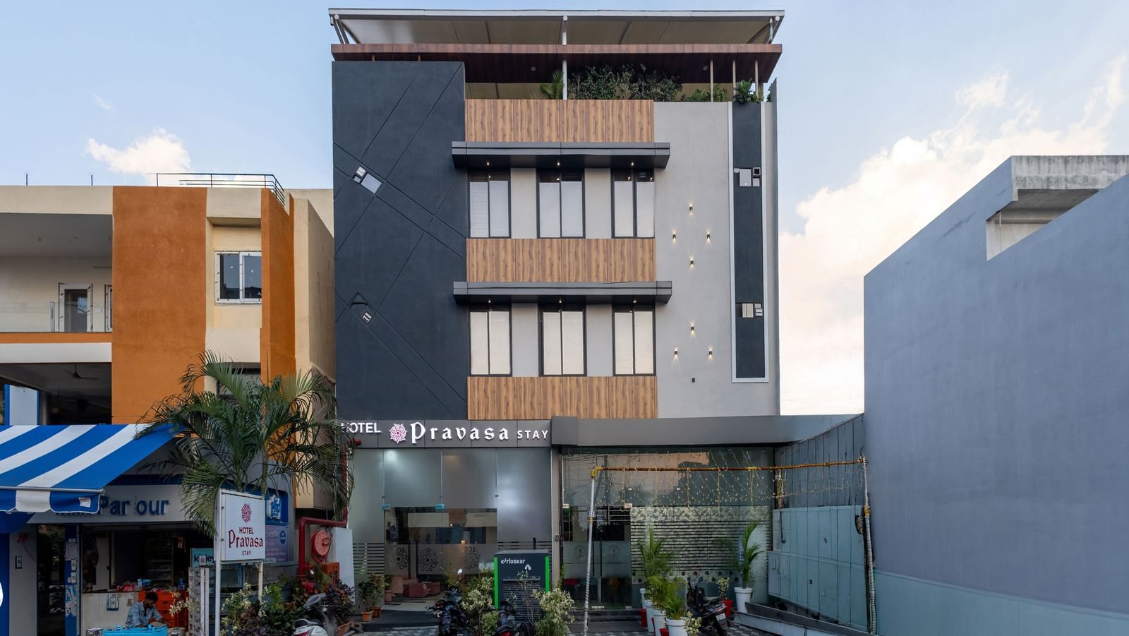 The facade of a modern multi-storey Pravasa Stay Dewas Naka, Indore under the blue sky.