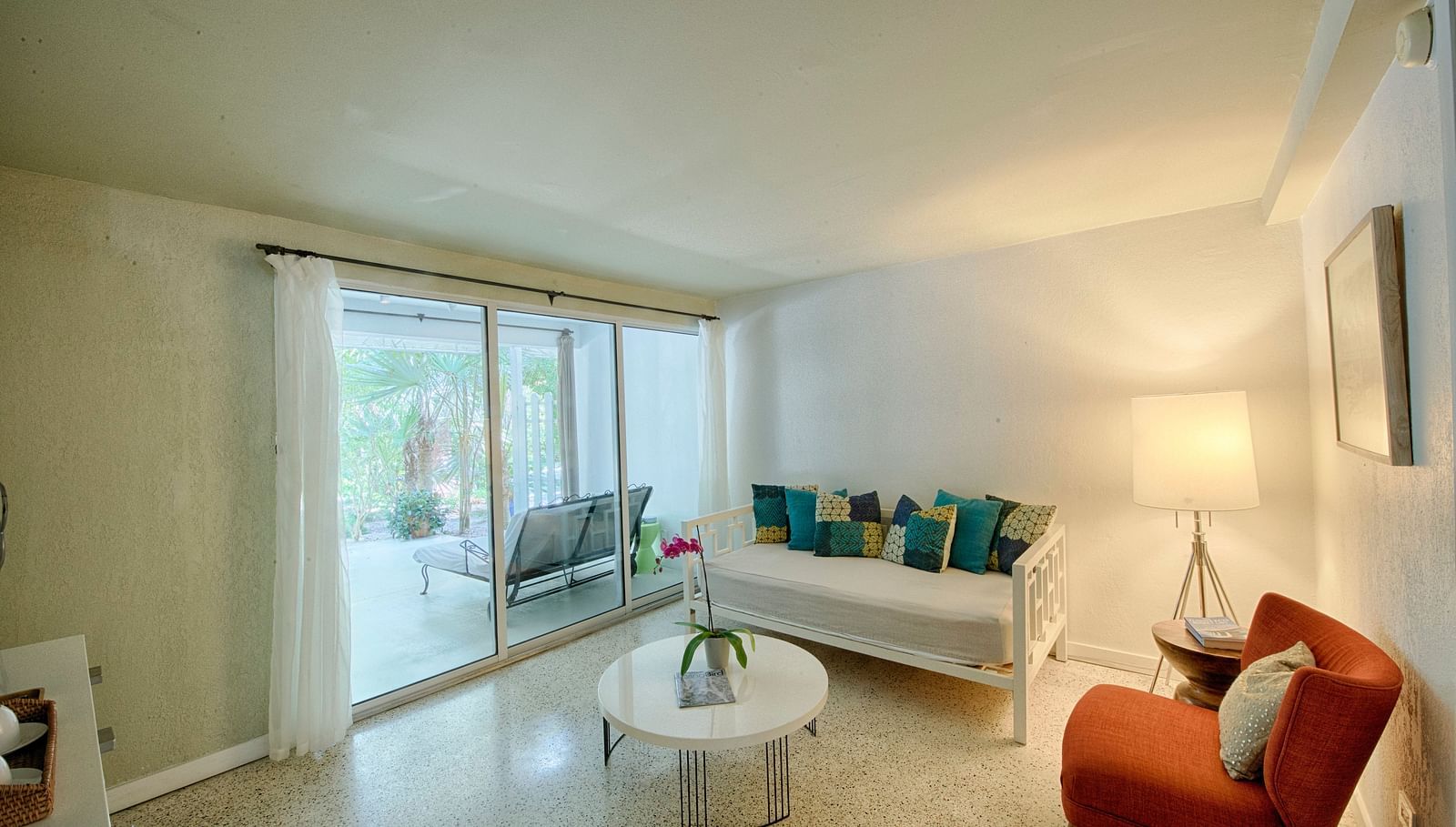 Sitting area at Casa Morada with a sofa, armchair, and coffee table next to a sliding glass door.