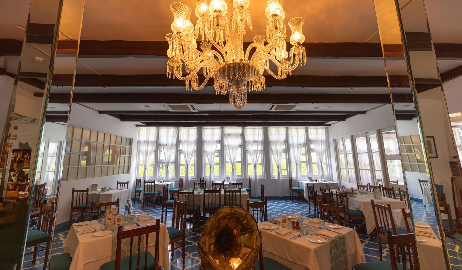 Interiors of Azrak Restaurant at Saraca Hotel, Lucknow with dining arrangement placed in front of large windows