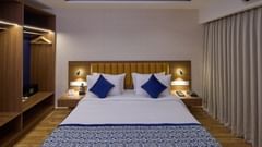A hotel room in Bangalore with a large bed and bed side lamps - Grand Continent, Brookefield