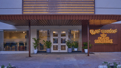 The main entrance to our hotel in Brookefield with potted plants and a signage representing our hotel name - Grand Continent, Brookefield