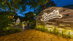 Exclusive Dining and BExterior view of the resort sign at night with lush surroundings at Heritage Village Resorts & Spa