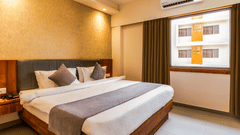 view of a king size bed of a room at Pride Elite Becharaji