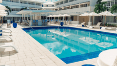 Central pool at The Soco House surrounded by lounge chairs and umbrellas.