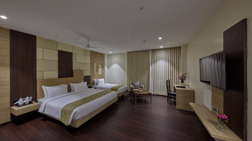 Overview of the family room with a king bed and a single bed in the family room at Grand Continent - A Sarovar Premiere Affiliate Hotel, Hosur