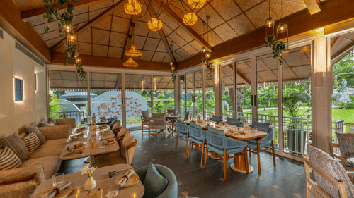 Bright and airy restaurant with wooden interiors, large windows, and scenic outdoor views.