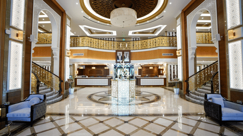 overview of the Lobby with staircase on either side leading to the top floors - La Maison Hotel, Doha
