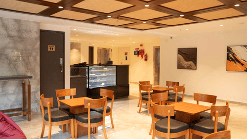 Indoor dining space at Magnus Lxia Premier, Kalyani Nagar with wooden furniture and warm lighting.