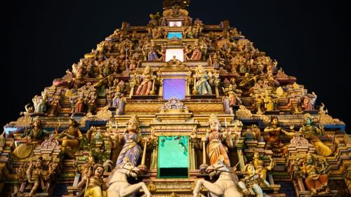 an old south indian style temple with lots of horses and other idols constructed on the exterior