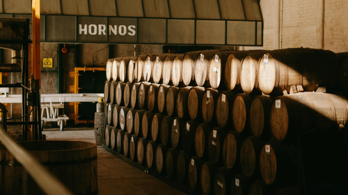 A large warehouse filled with stacked wooden barrels.