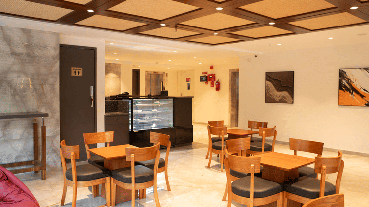 Indoor dining space at Magnus Lxia Premier, Kalyani Nagar with wooden furniture and warm lighting.