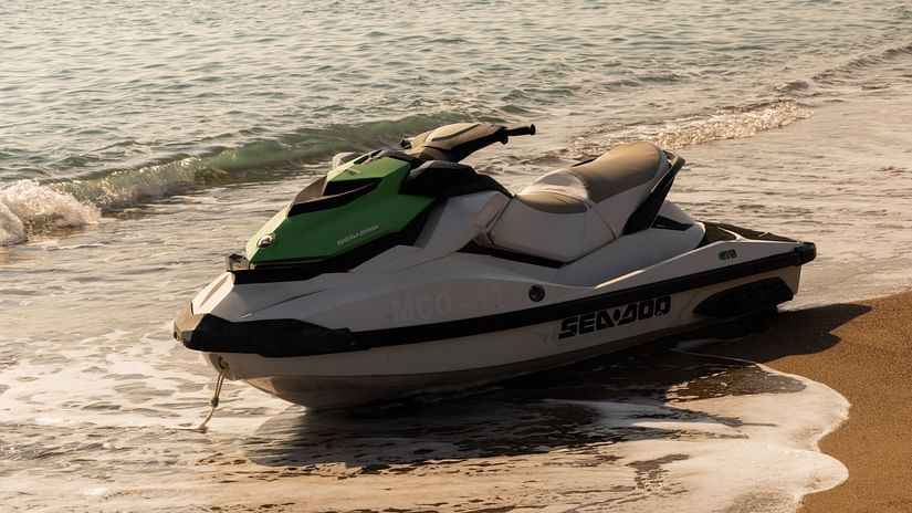 A jet ski parked on the beach with waves overlapping on the beach
