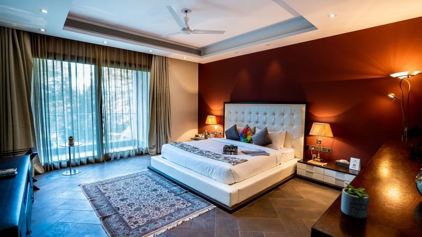 A double bed with side tables and lamps inside one of the rooms of Woodpecker Villa - Karma Lakelands.