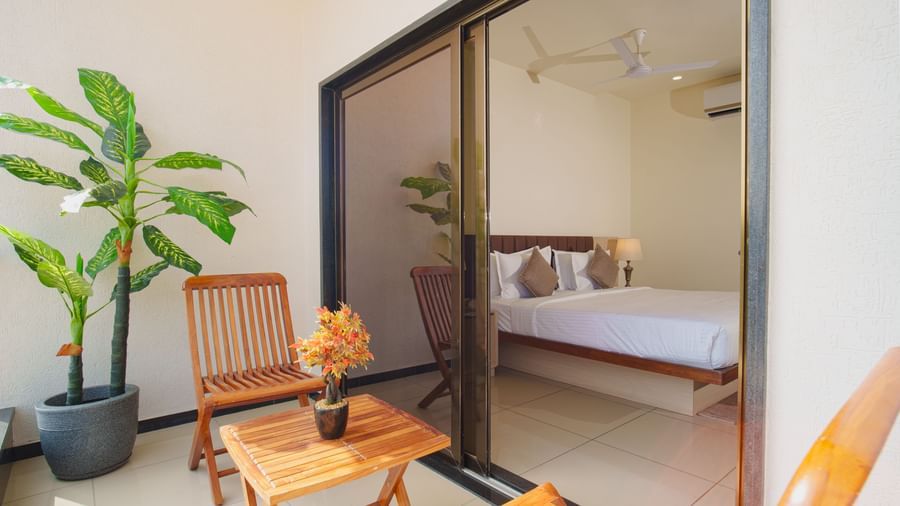 Hotel room view showing a small seating area on an outdoor balcony or patio next to a glass door at Arawali Ananta Elite, Jaipur.