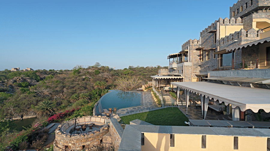A side view of Chunda Shikar Oudi with the swimming pool and forest cover with the sky in the background