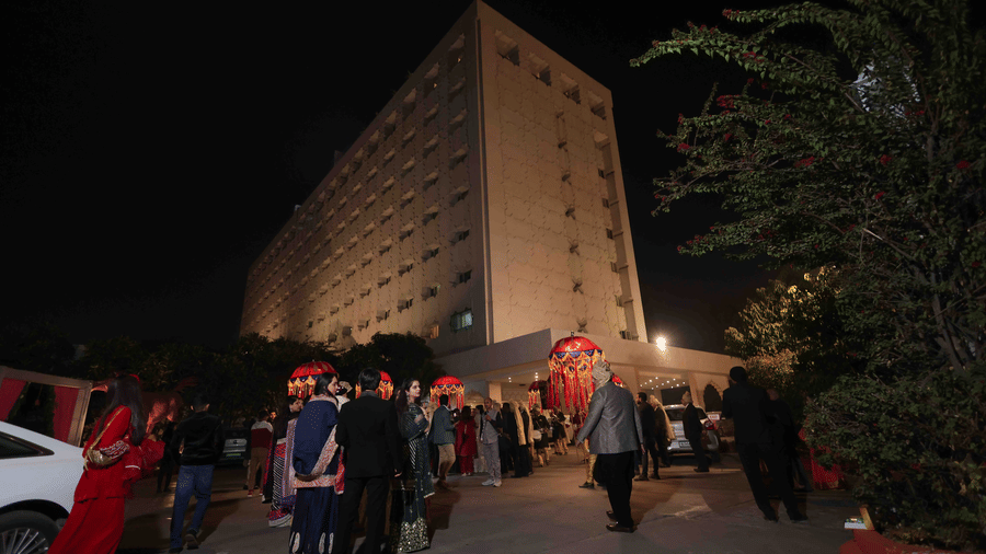 Guests arriving for a wedding celebration at Clarks Amer, Jaipur, with traditional decor and festive evening lighting at the hotel entrance.