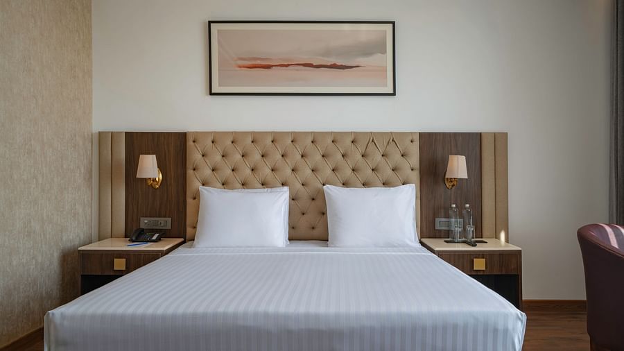 Modern hotel room with a minimalist design and natural light - Clarks Inn, Dehradun
