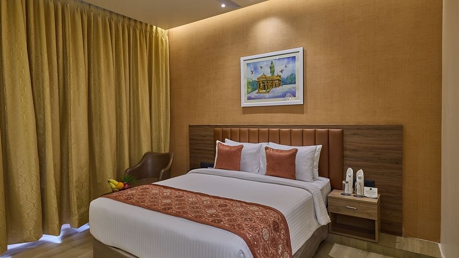 A comfortable bed with a painting placed above its headboard