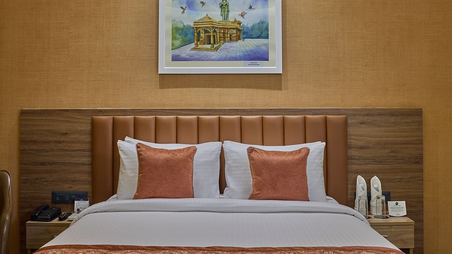 A close up shot of a large bed with orange and white pillows