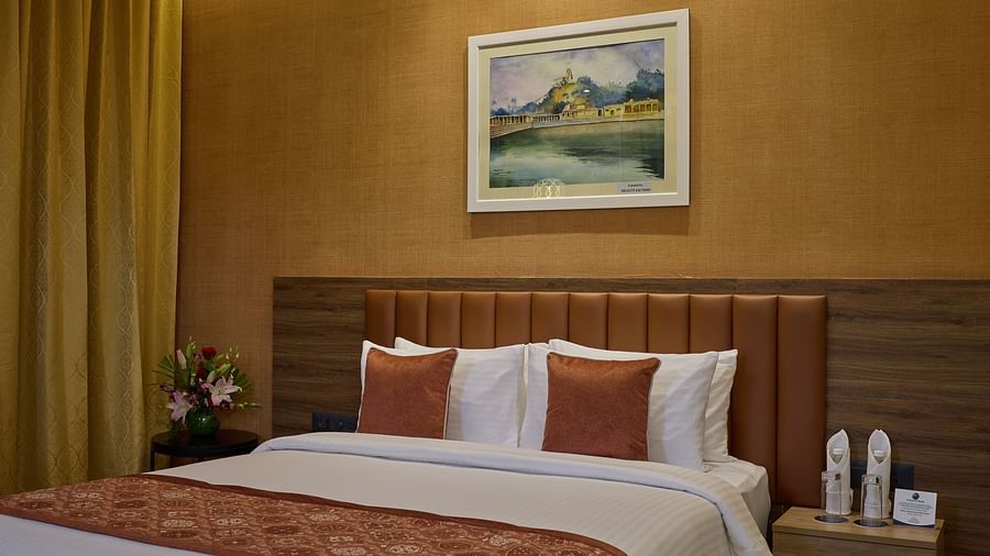 An image of a queen size bed beside a night stand