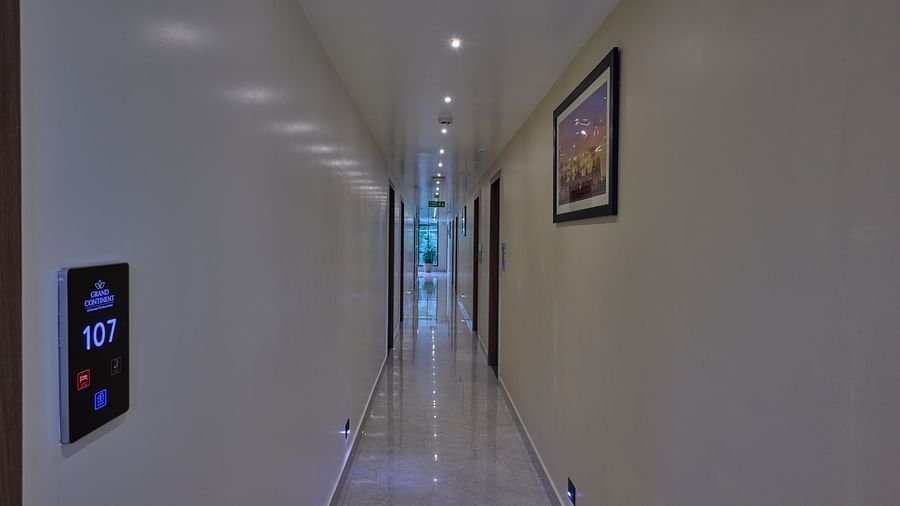 A corridor in our hotel, featuring wall-mounted electronic signboards displaying the room numbers