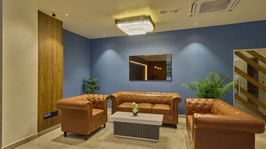 An image of the hotel lobby with orange couches places around a coffee table