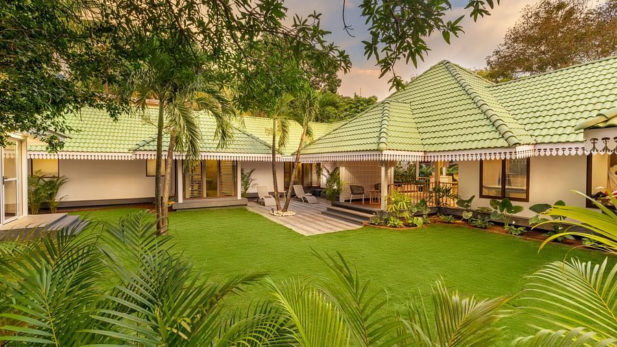 Green-roofed villas surrounded by tropical trees and well-kept garden space.