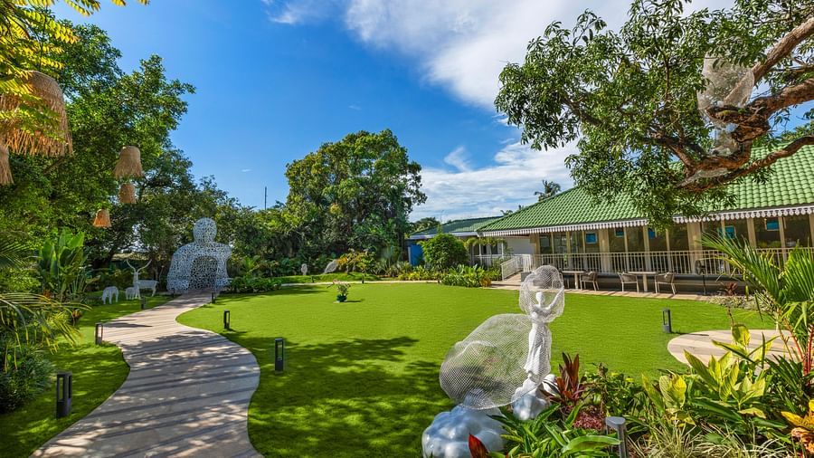 Garden pathway leading to a gazebo, surrounded by lush greenery and manicured lawns.