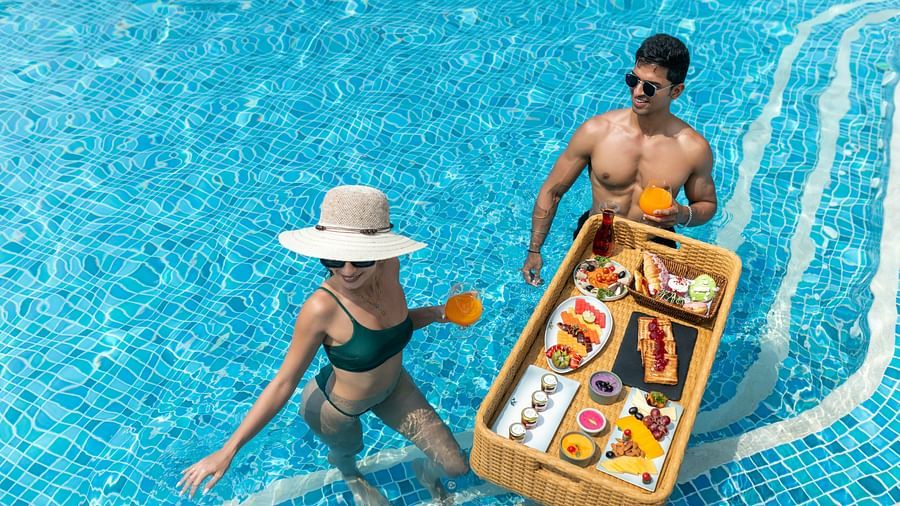 A couple enjoying a poolside breakfast in the water at Heritage Village Resorts & Spa.