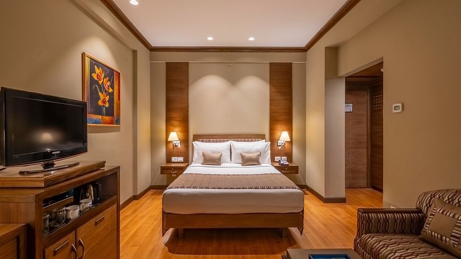 front view of a double bed with beige linen in the Business Club Room at Kenilworth Hotel, Kolkata